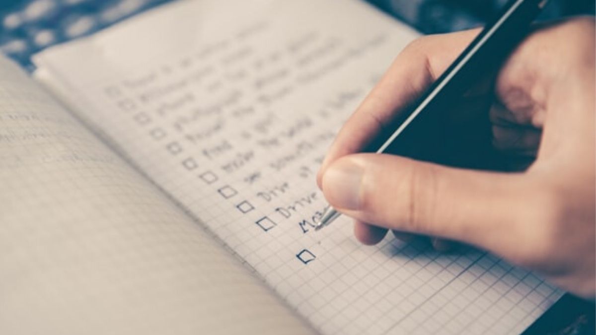 man writing down on paper using ivy lee method